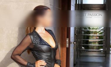 SP Escort Agency Munich, Christin in a black dessous dress, stockings and highheels. Standing in an entry way.